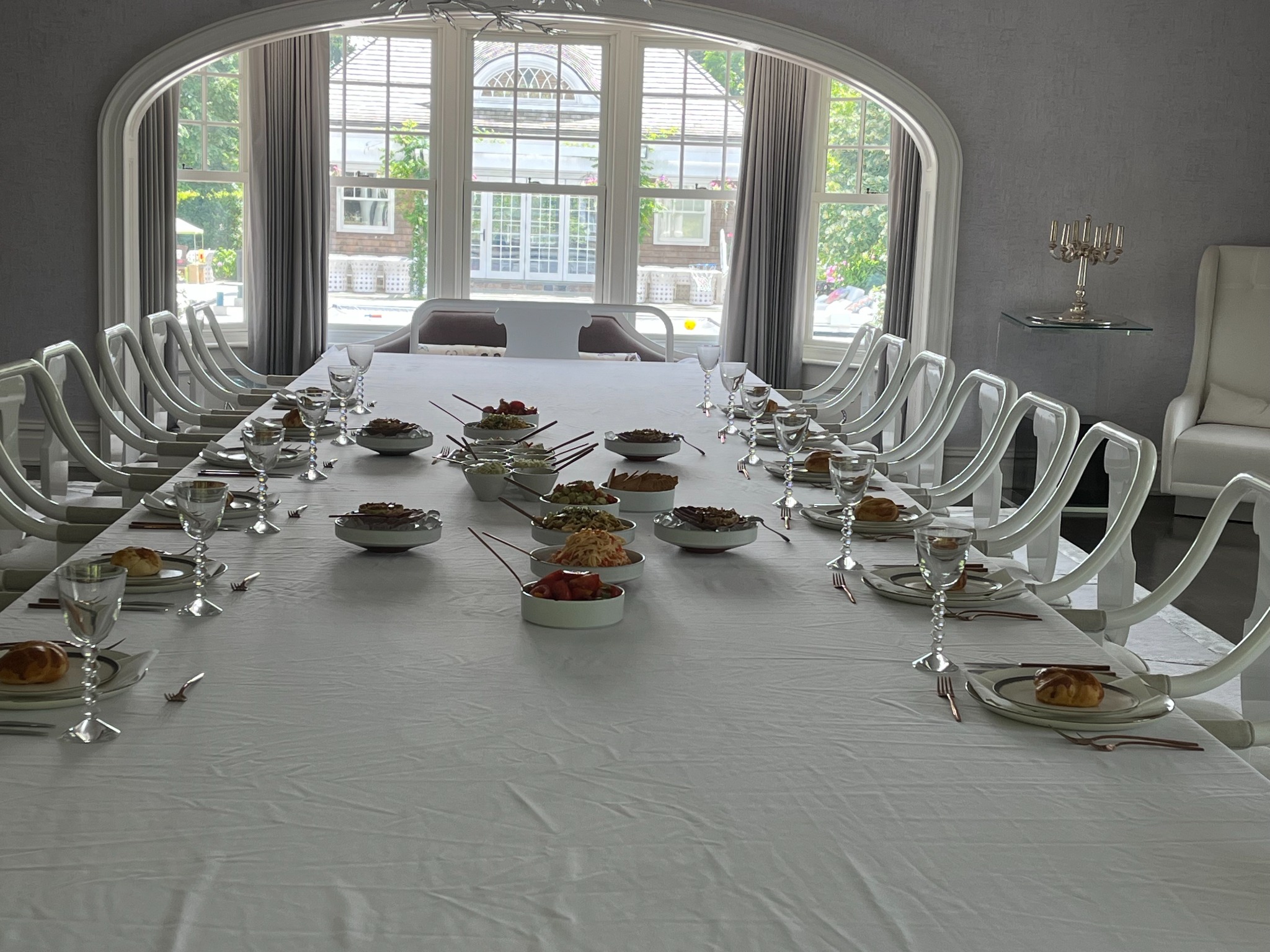 Elegant kosher dining table in front of an arched window
