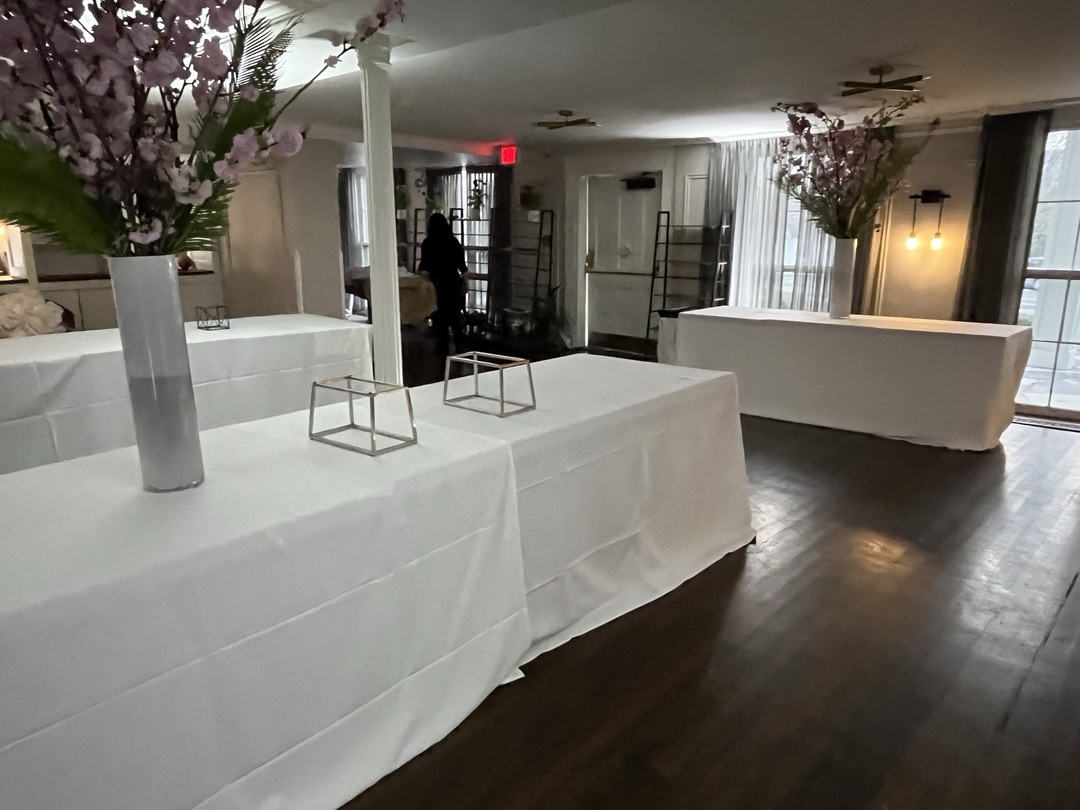 Event buffet area with white linens and floral arrangements