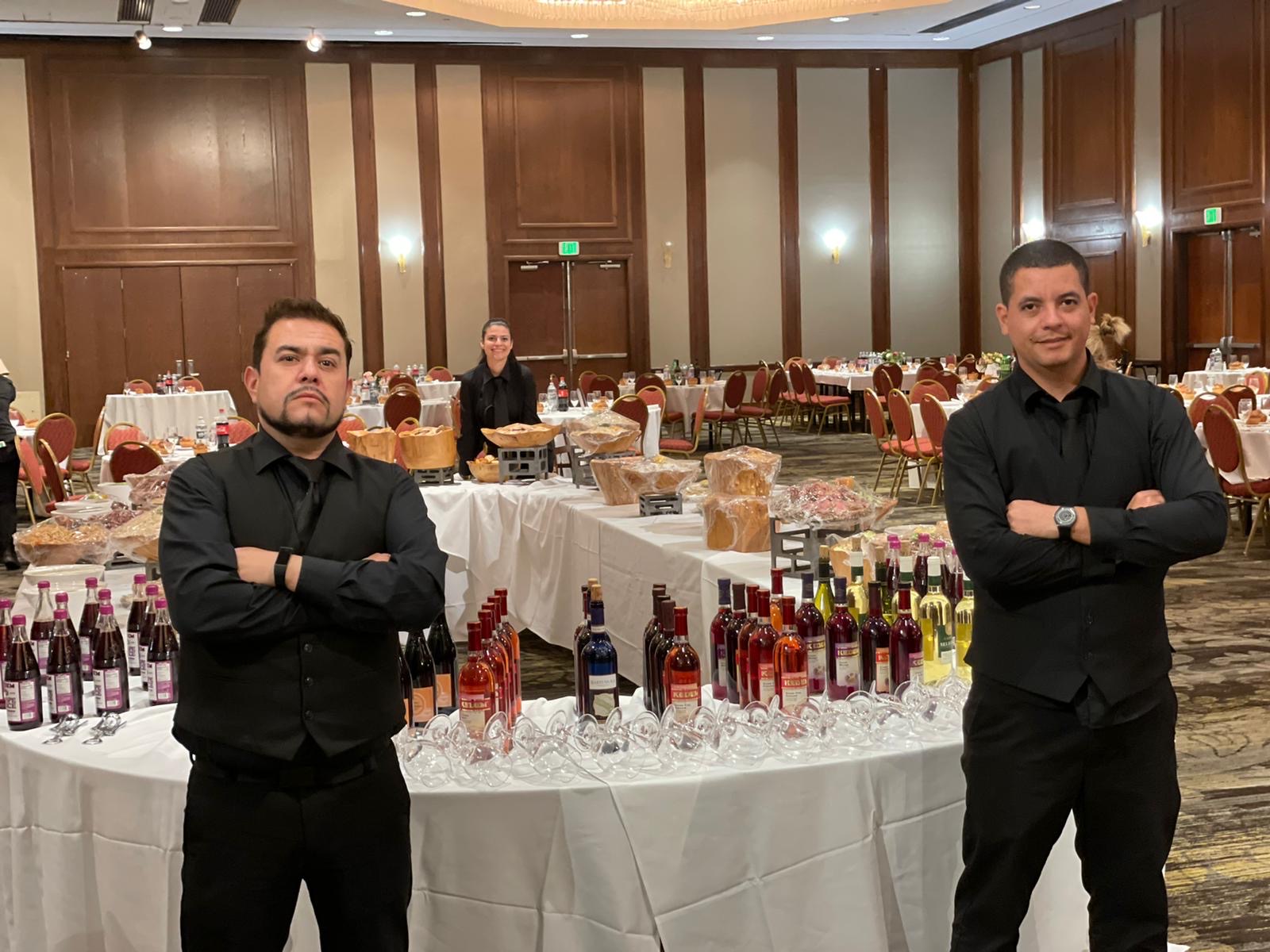 Professional event staff in front of a beverage and buffet setup